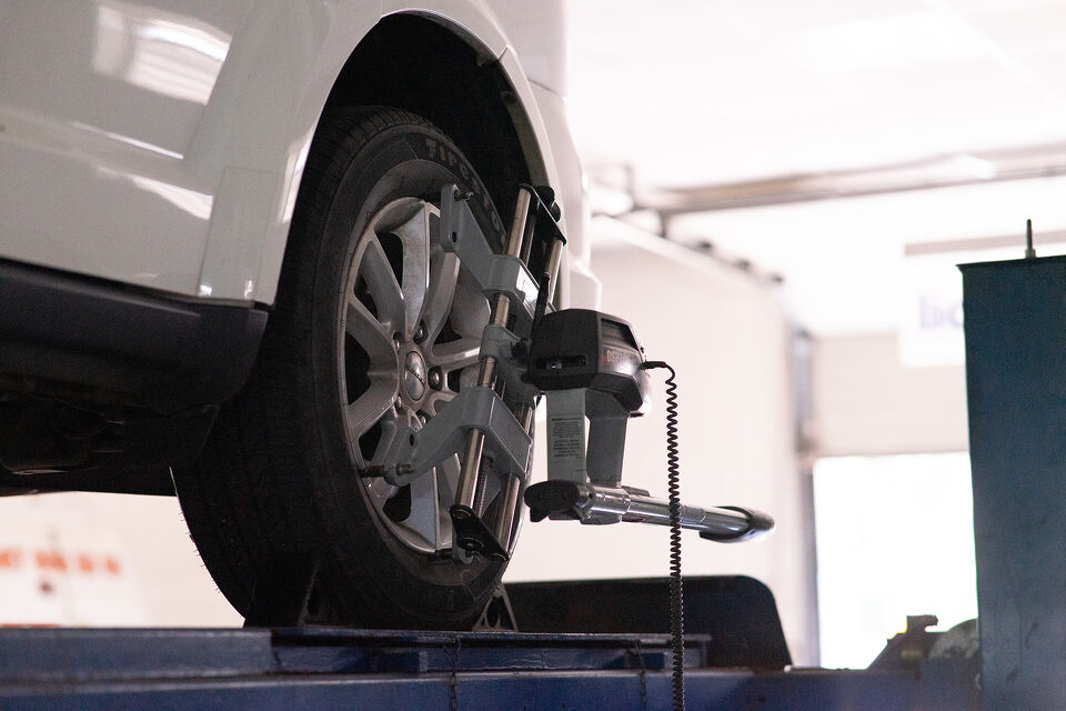 Wheel alignment equipment fitted to a car raised on a workshop hoist