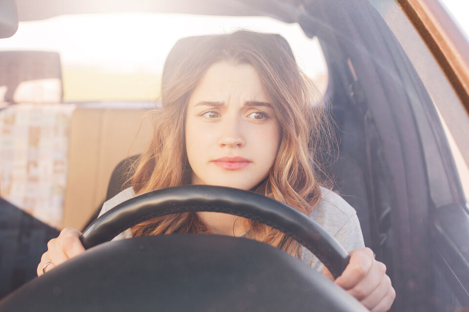 Worried woman gripping the steering wheel while driving