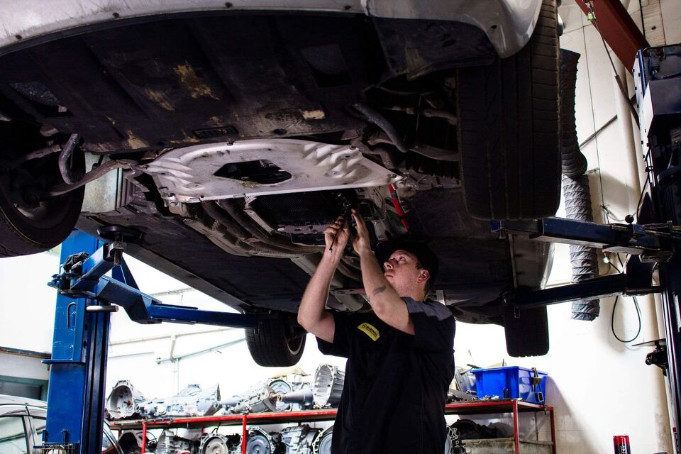 Mechanic working underneath a car raised on a hoist
