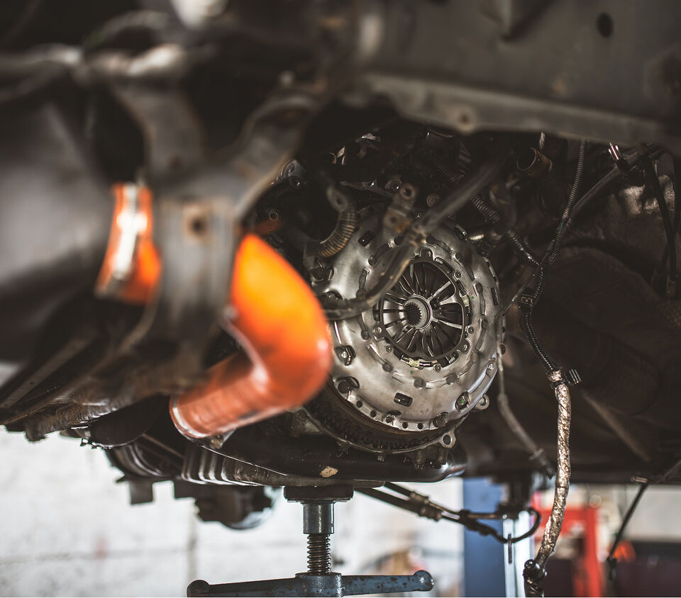 Close-up of a clutch and transmission housing underneath a raised car